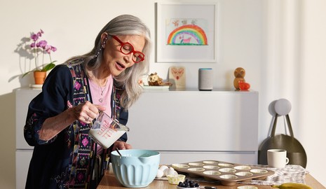 woman baking while talking to smart speaker